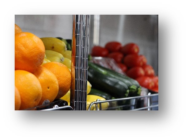 Shelves holding fresh fruit (oranges) and vegetables (yellow squash, zuchinia, and Roma tomatoes) inside the UALR University District mobile market.